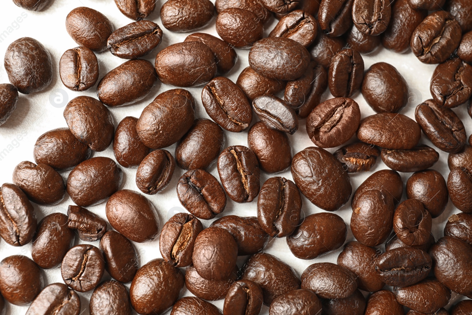 Photo of Roasted coffee beans on white background, top view