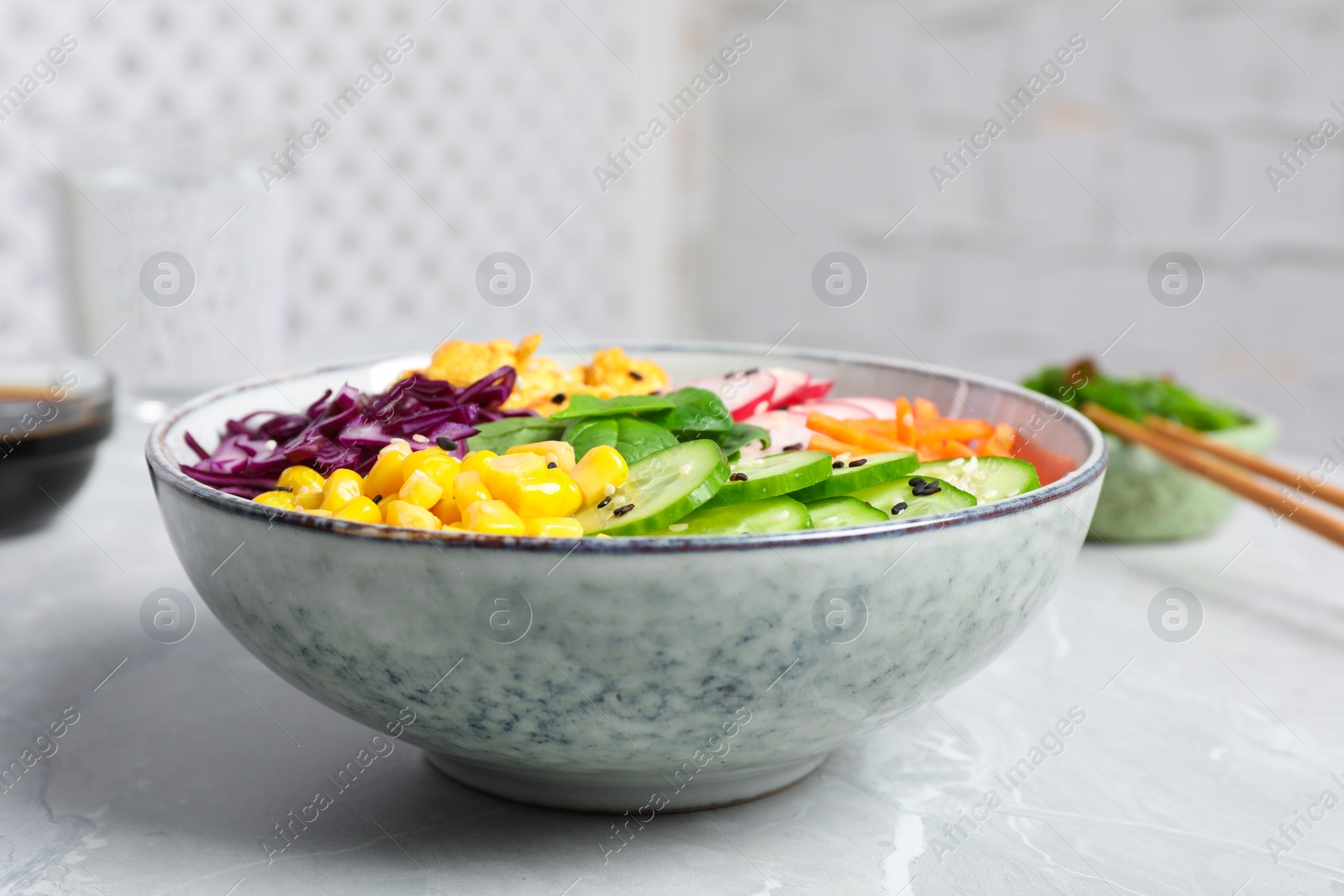 Photo of Delicious salad with chicken, vegetables and spinach on grey marble table