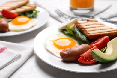 Delicious breakfast with fried eggs served on white table, closeup