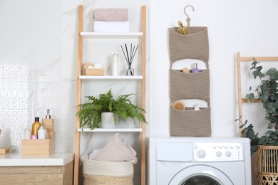 Knitted organizer hanging on wall in bathroom