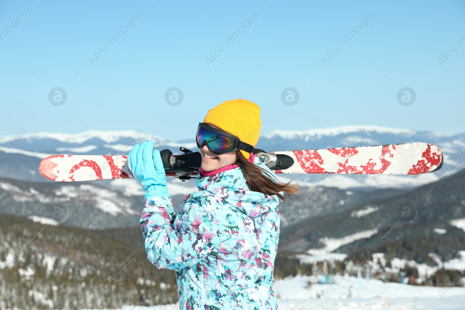 Photo of Young woman with ski equipment in mountains. Winter vacation