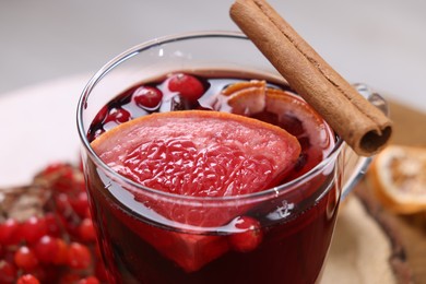 Photo of Aromatic mulled wine in glass cup on table, closeup