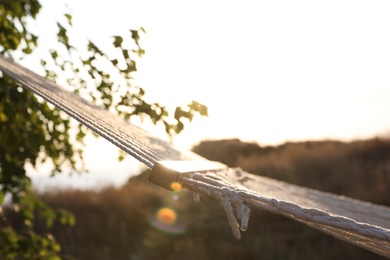 Photo of Empty hammock hanging outdoors. Time to relax