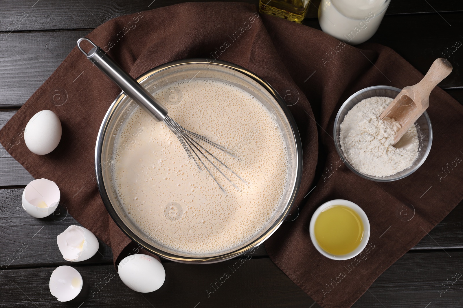 Photo of Flat lay composition with whisk and dough in bowl on wooden table