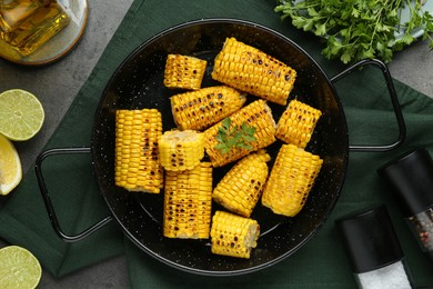 Flat lay composition with tasty grilled corn on dark grey table