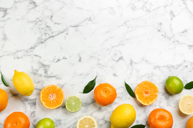 Photo of Flat lay composition with tangerines and different citrus fruits on white marble background. Space for text