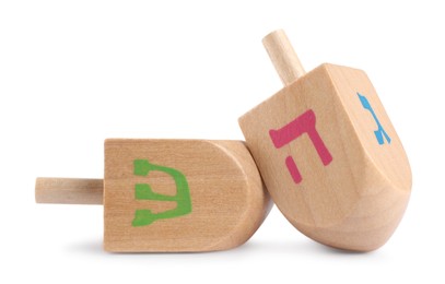 Photo of Hanukkah celebration. Wooden dreidels with jewish letters isolated on white