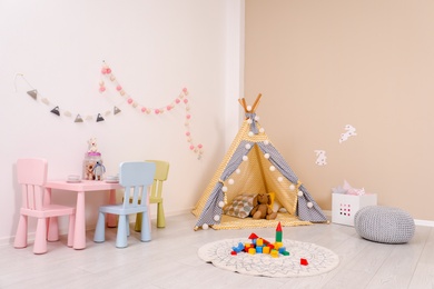 Cozy child room interior with play tent, table and modern decor elements