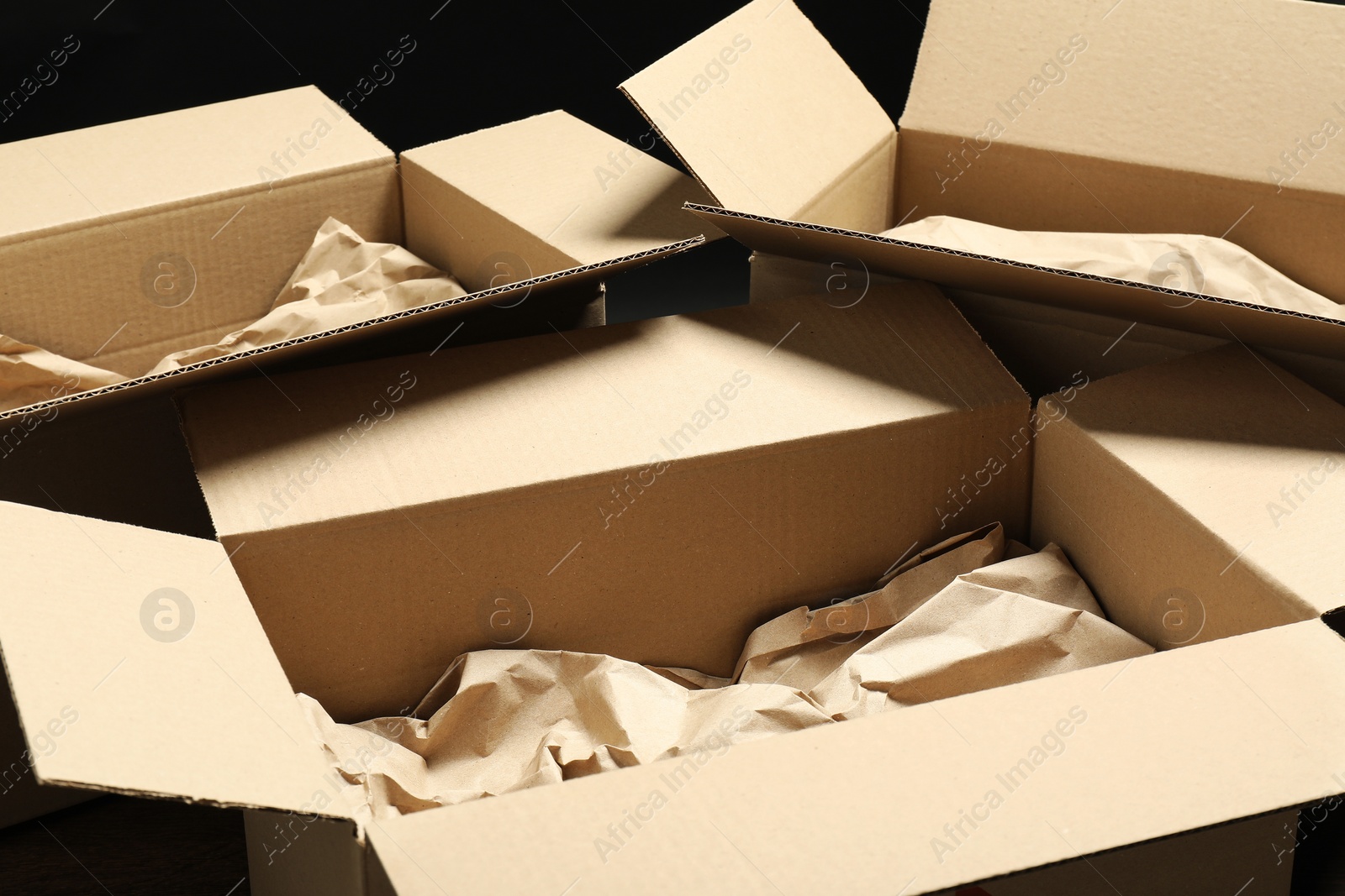 Photo of Open cardboard boxes with crumpled paper. Packaging goods