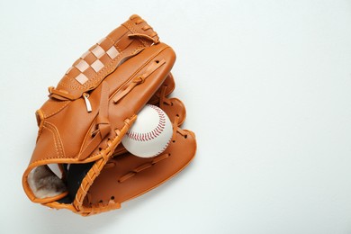 Photo of Catcher's mitt and baseball ball on white background, top view with space for text. Sports game