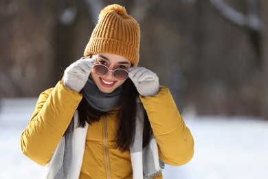 Photo of Portrait of beautiful young woman with sunglasses on winter day outdoors
