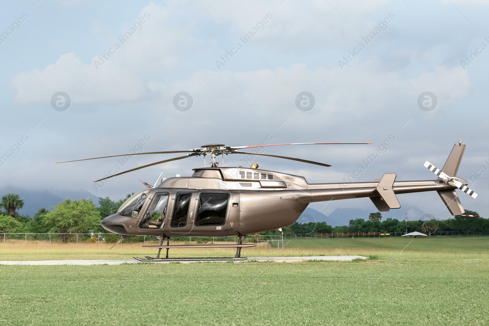 Photo of Beautiful modern helicopter on helipad in field