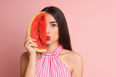 Photo of Beautiful young woman posing with watermelon on color background