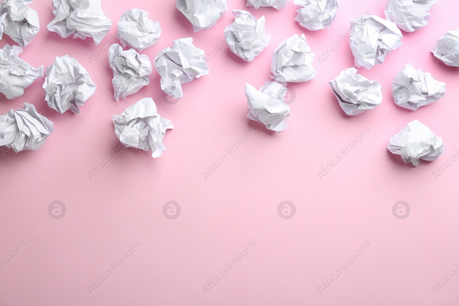 Photo of Crumpled sheets of paper on light pink background, flat lay. Space for text