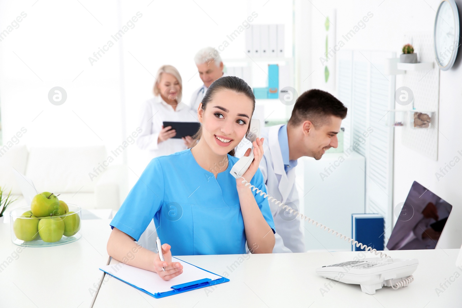 Photo of Young female receptionist working in hospital