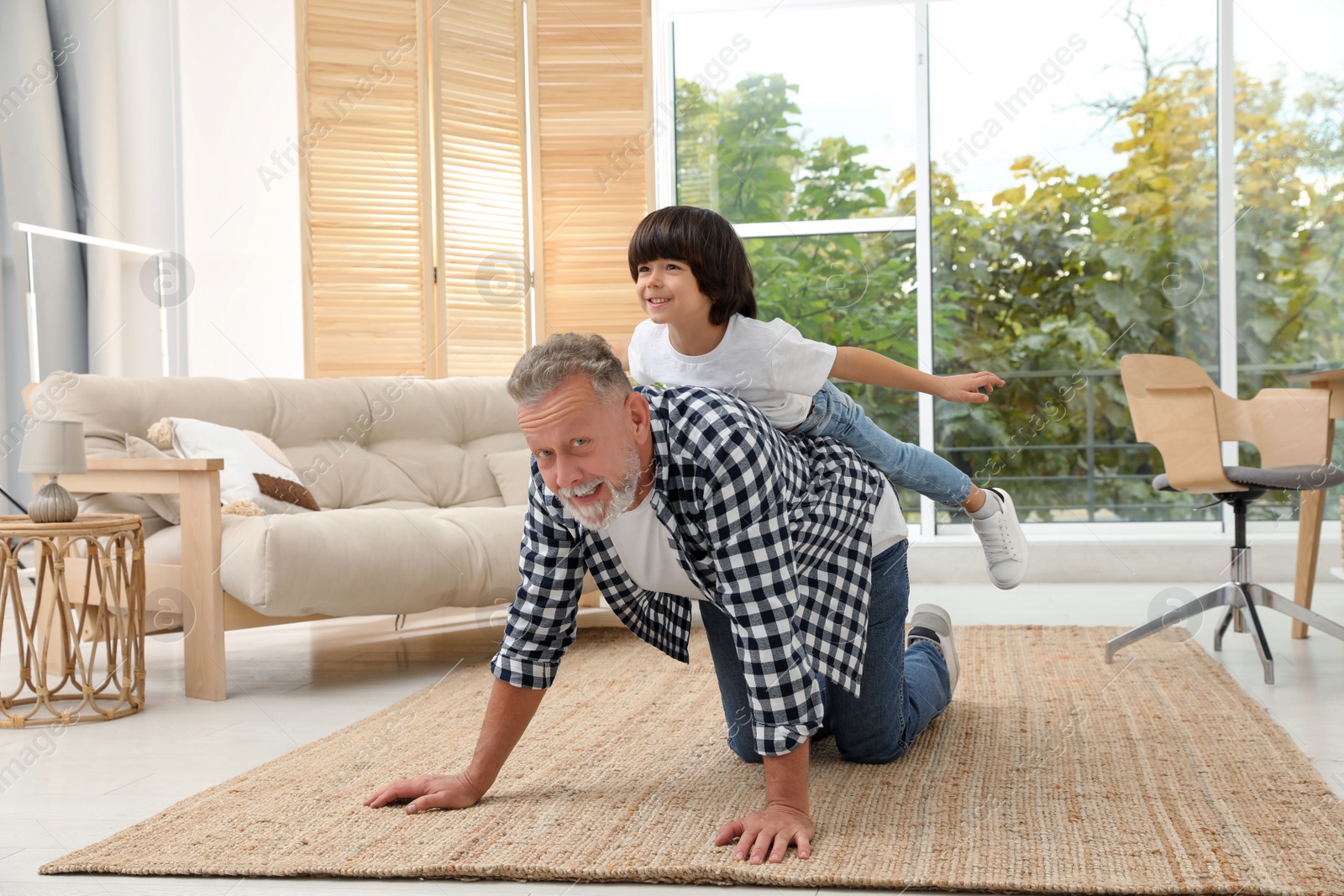 Photo of Happy grandfather with his grandson playing together at home