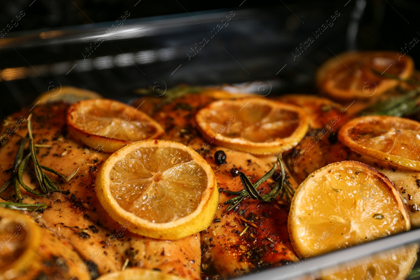 Photo of Delicious lemon chicken in oven, closeup view
