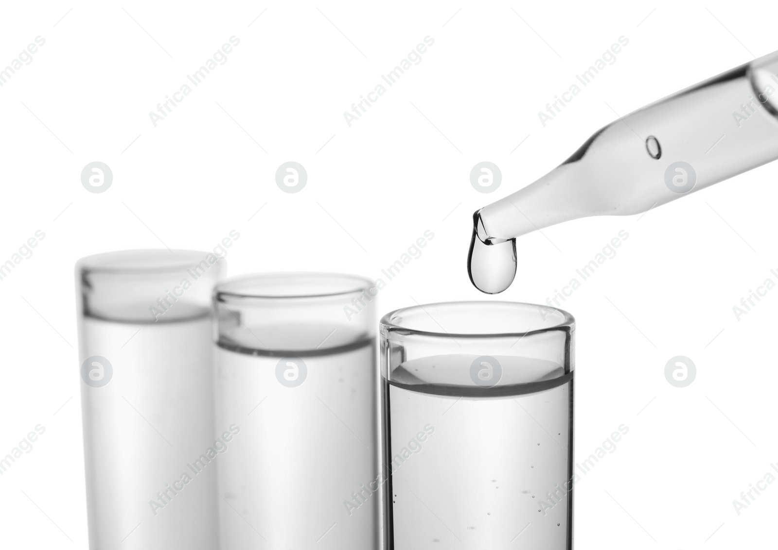 Photo of Dripping transparent liquid into test tube on white background, closeup