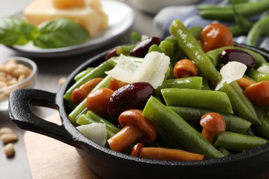 Delicious salad with green beans, mushrooms and cheese on table, closeup