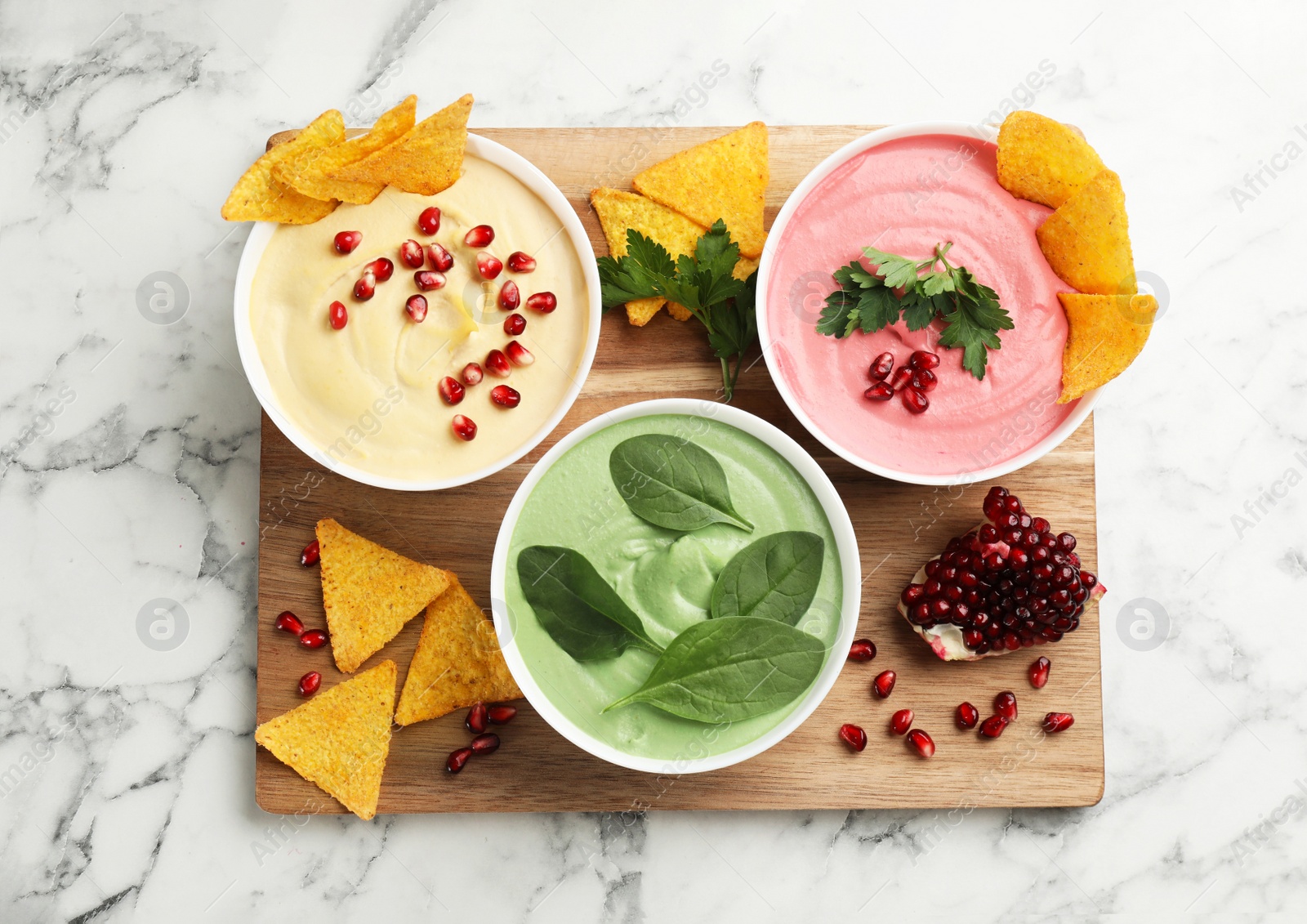 Photo of Composition with delicious hummuses on white marble table, top view