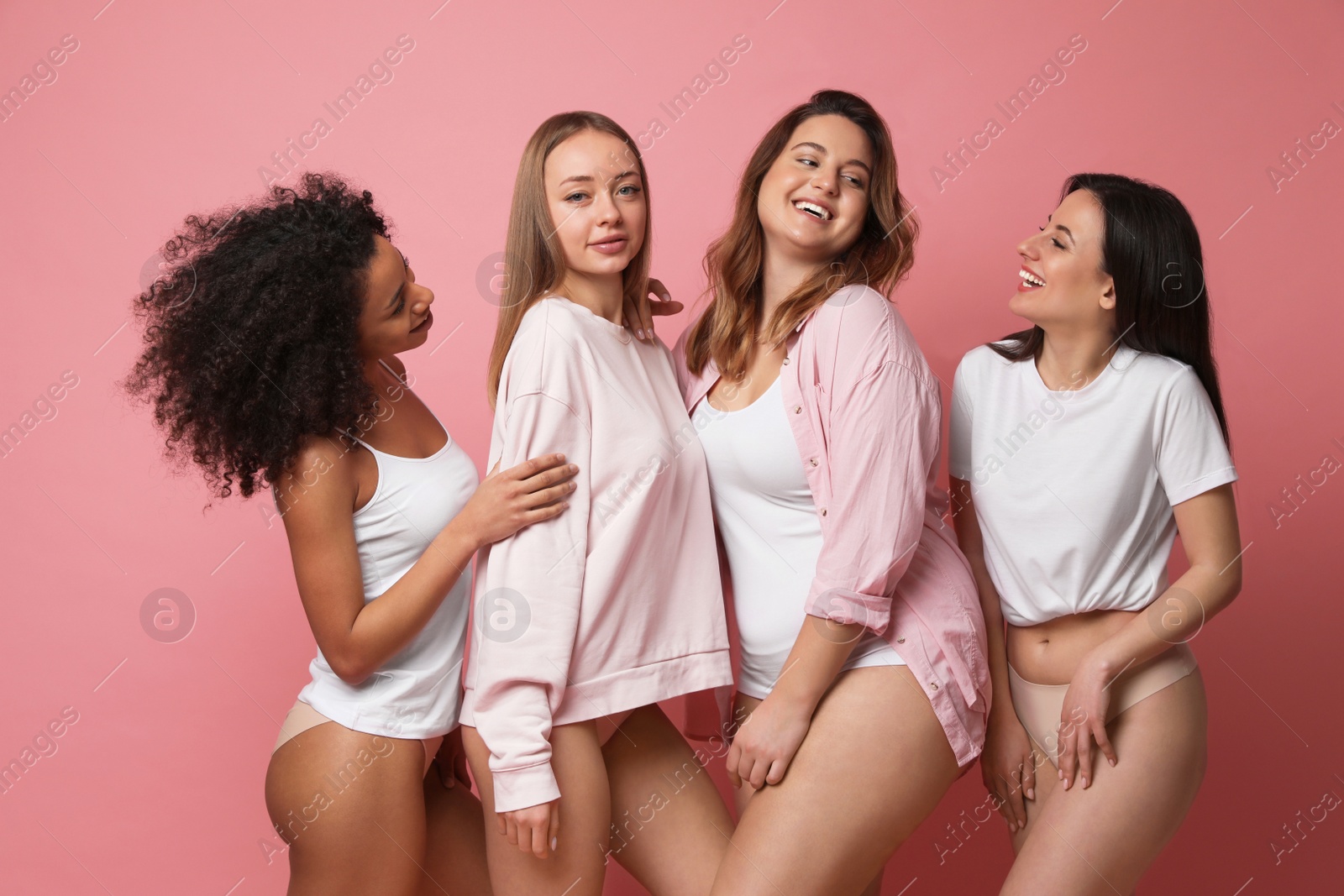 Photo of Group of women with different body types in underwear on pink background