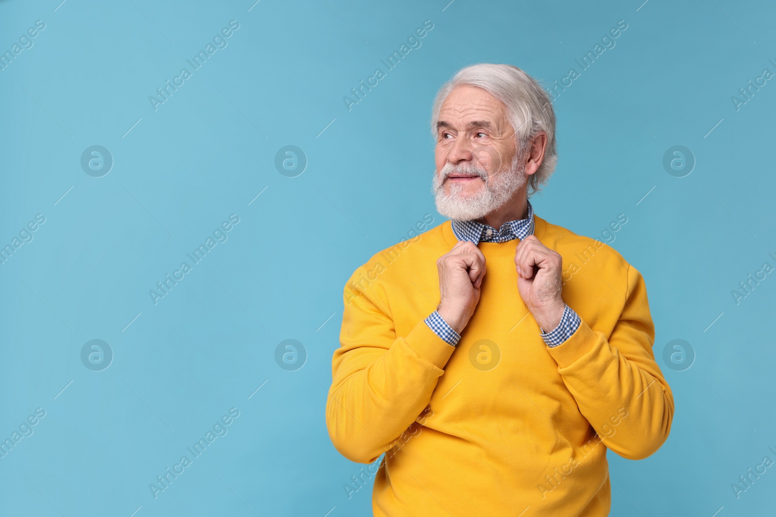 Photo of Portrait of stylish grandpa on light blue background, space for text
