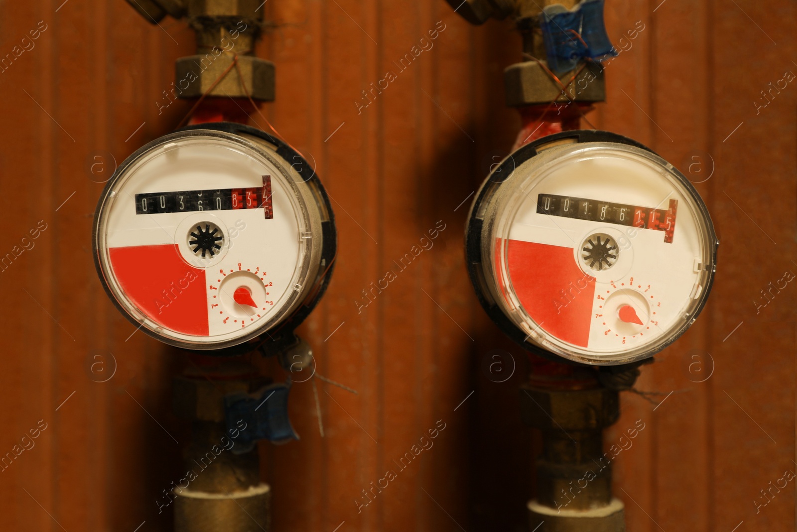 Photo of View of two electric meters near red brick wall. Water measuring device