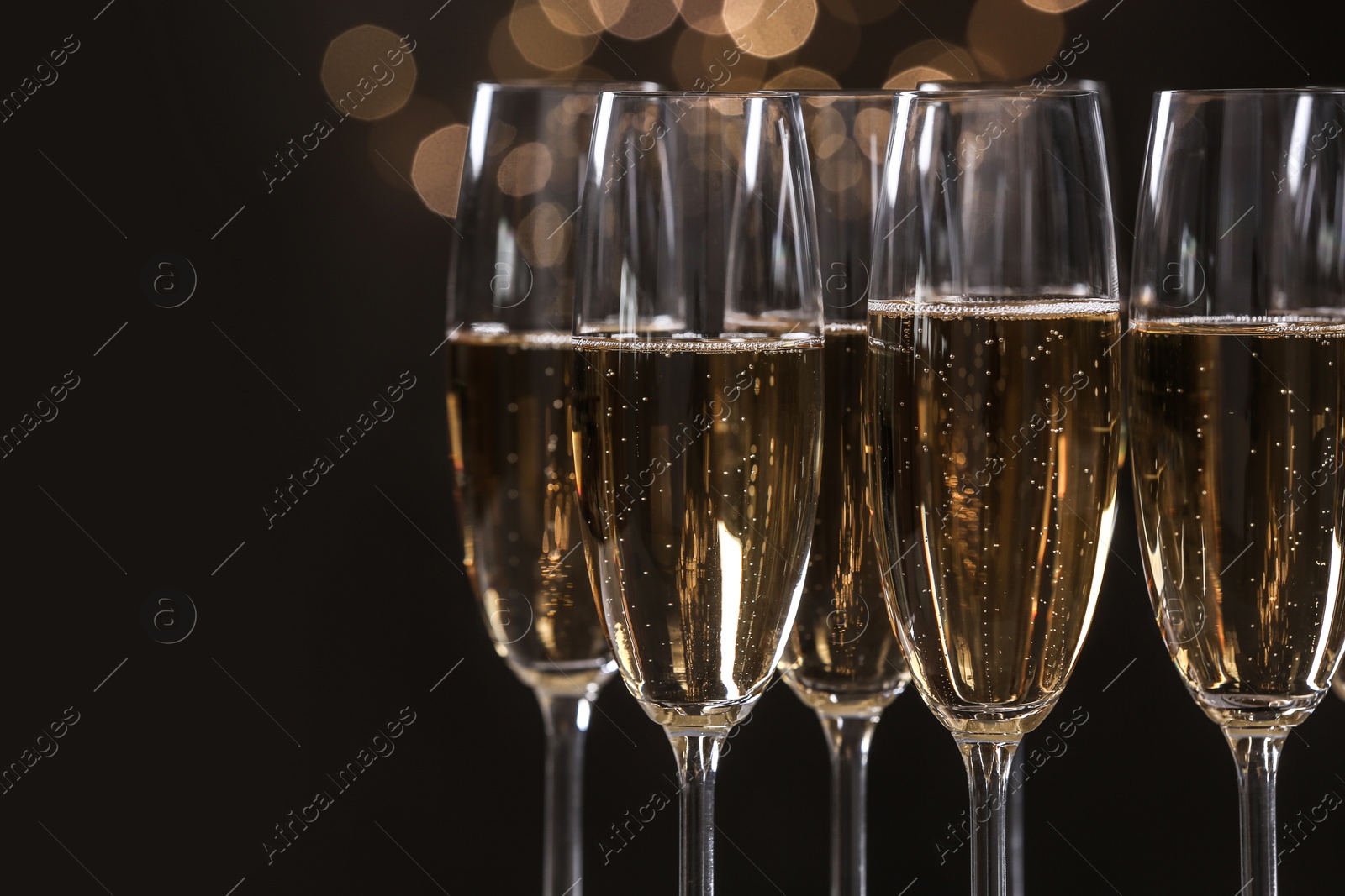 Photo of Glasses of champagne on blurred background, closeup. Space for text