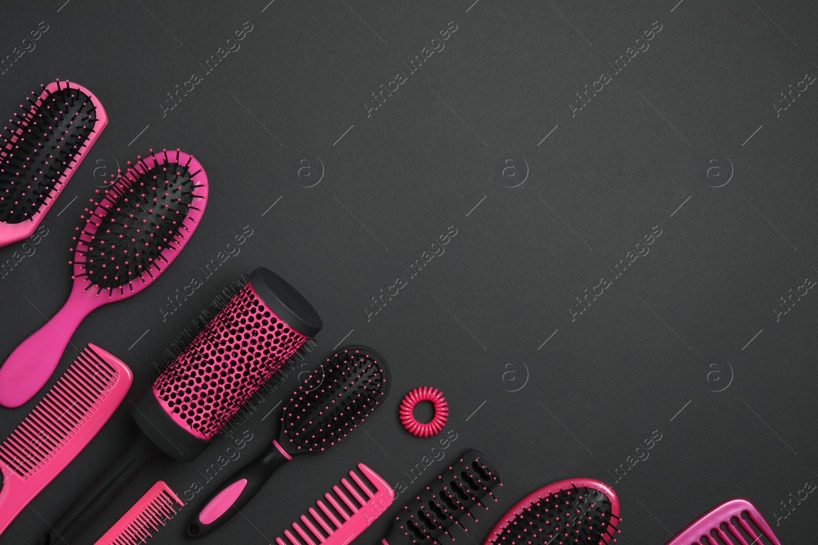 Photo of Flat lay composition with modern hair combs and brushes on black background