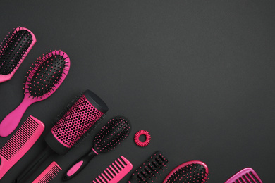 Flat lay composition with modern hair combs and brushes on black background