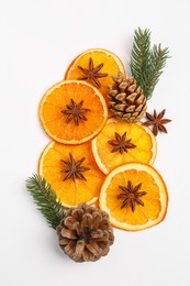 Photo of Dry orange slices, anise stars, fir branches and cones on white background, flat lay