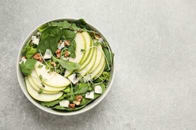 Photo of Tasty salad with pear slices on light grey table, top view. Space for text