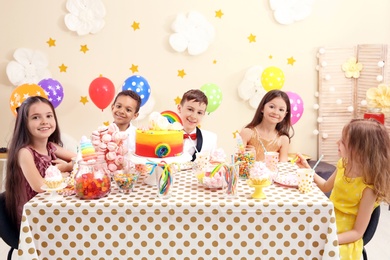 Cute children celebrating birthday at table indoors