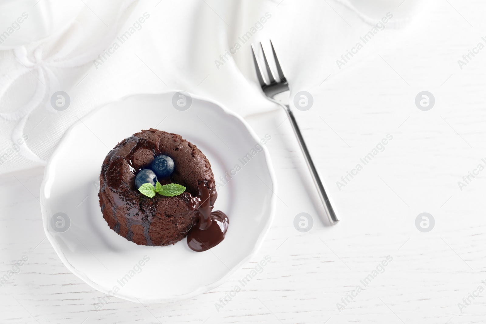 Photo of Plate of delicious fresh fondant with hot chocolate and blueberries on table. Lava cake recipe