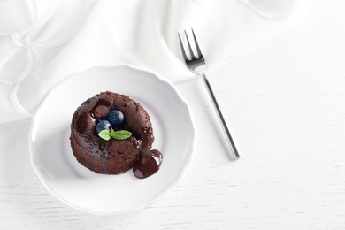 Plate of delicious fresh fondant with hot chocolate and blueberries on table. Lava cake recipe