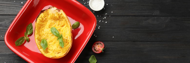 Image of Half of cooked spaghetti squash in baking dish and ingredients on black wooden table, flat lay. Banner design with space for text