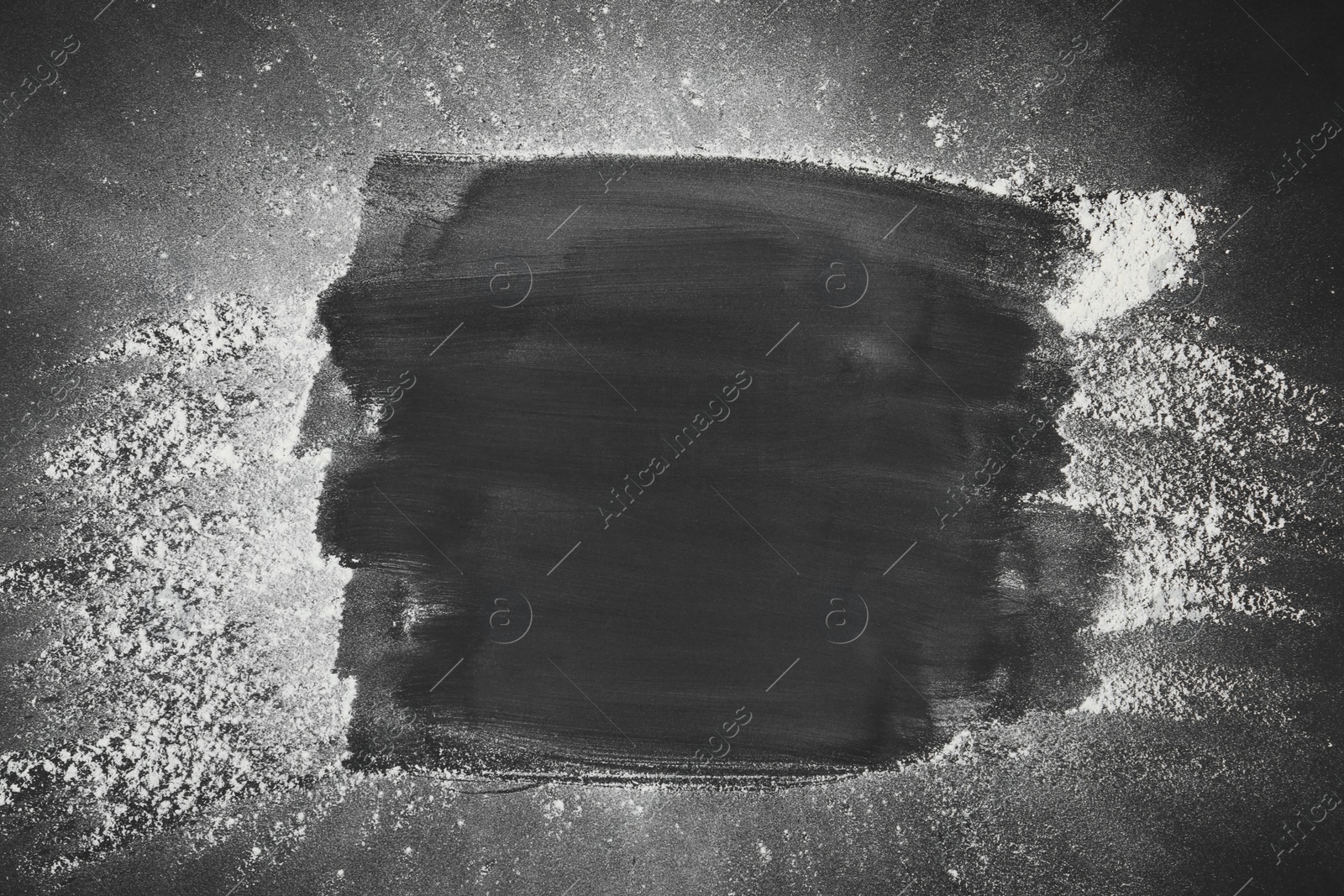 Photo of Frame made with flour on black table, top view. Space for text