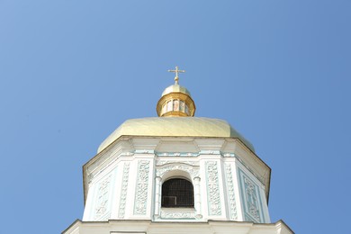 Photo of Beautiful church with golden dome against blue sky, low angle view