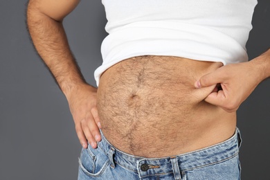 Photo of Overweight man on gray background, closeup view