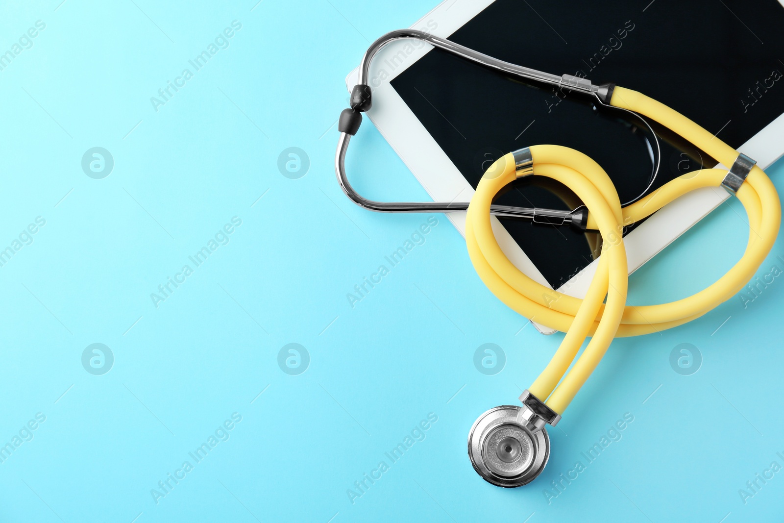 Photo of Stethoscope and tablet on color background, top view. Medical equipment