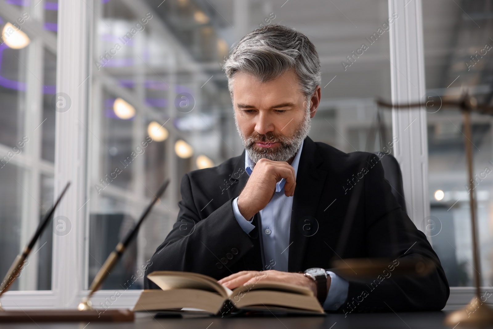 Photo of Portrait of confident lawyer at table in office