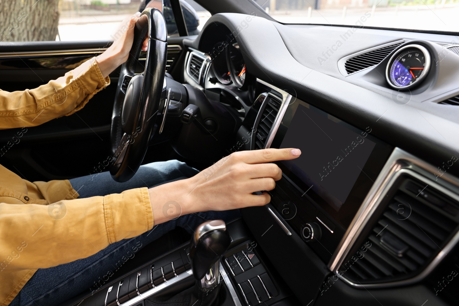 Photo of Woman using navigation system while driving her car, closeup