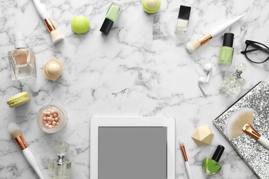Photo of Frame made with tablet and beauty blogger's accessories on marble table, top view