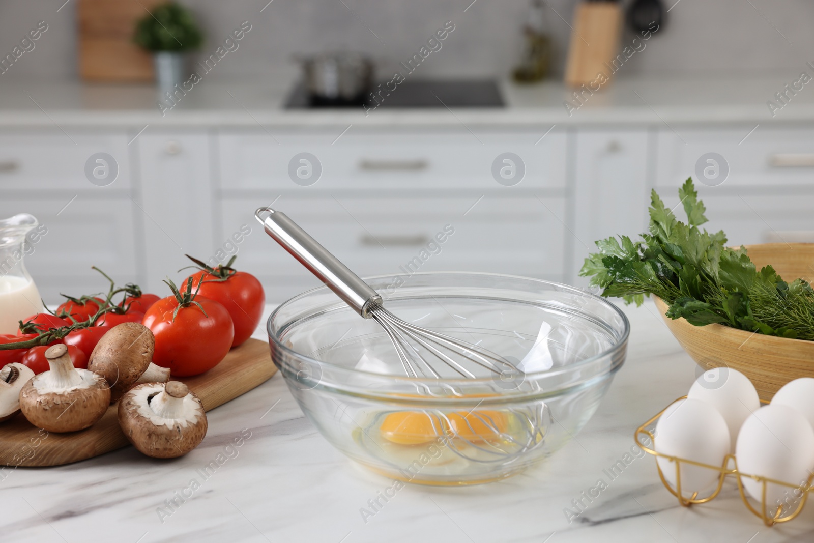 Photo of Whisk, bowl, and different ingredients on white marble table indoors