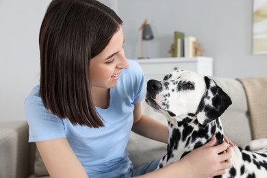 Photo of Beautiful woman with her adorable Dalmatian dog indoors. Lovely pet