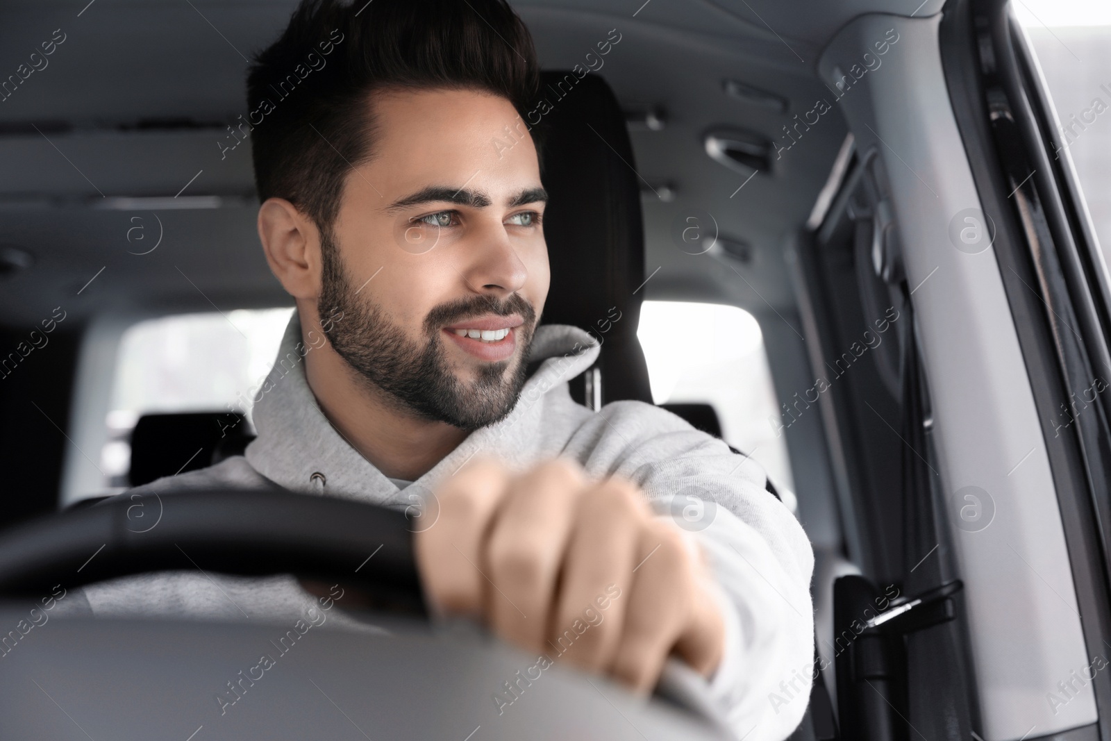 Photo of Handsome young man driving his modern car