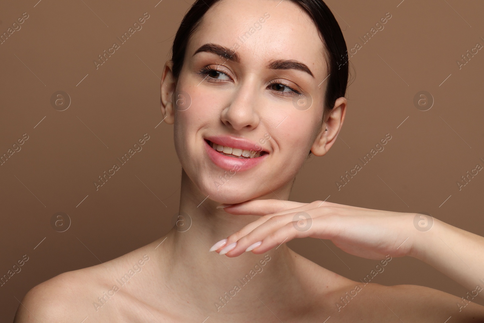 Photo of Portrait of beautiful young woman on brown background