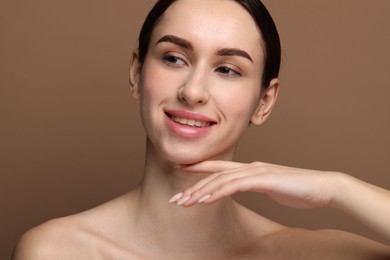 Portrait of beautiful young woman on brown background