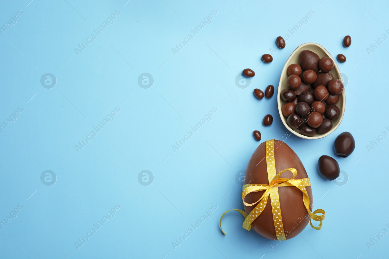 Photo of Tasty chocolate Easter eggs on color background, top view with space for text