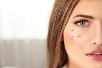 Photo of Young woman with fallen eyelashes on her face indoors. Space for text